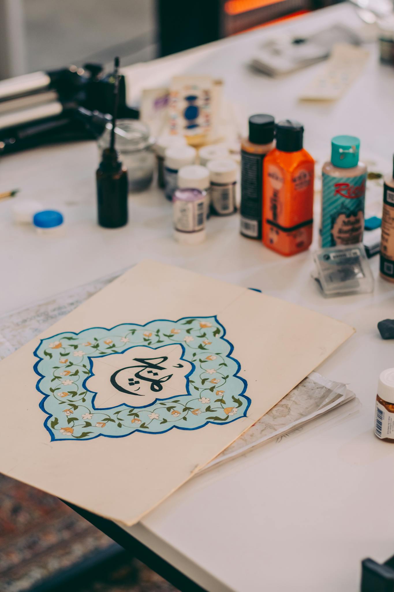 Creative workspace with art supplies and a patterned design on a table.